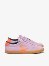 Championes Veja modelo Volley, confeccionados en gamuza color lila con detalles en naranja vibrante en el logo lateral y talón. Presentan suela de goma color caramelo y cierre con cordones al tono.