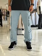 Pantalón cargo de jean azul claro, con corte oversize y múltiples bolsillos laterales en las piernas.