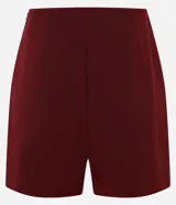 Short pollera de sastrería confeccionado en crepé, con diseño de frente traspasado, cintura alta estructurada y detalle de hebilla metálica lateral.