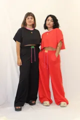 Pantalón de jogging de corte ancho y tiro alto, con cintura elástica, cordones ajustables y un aplique decorativo de acrílico en el frente. Cuenta con bolsillos laterales.