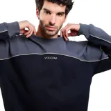 Buzo Volcom de cuello redondo en combinación de colores gris y negro, con diseño en bloques y el logo de la marca bordado en el pecho.