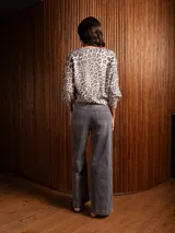 Buzo de punto con estampado animal print, cuello en V y mangas largas con puños ajustados.