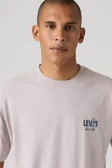 Remera de corte holgado estilo vintage de la marca Levi's, en color gris claro, con cuello redondo y mangas cortas. Presenta un pequeño estampado gráfico en el pecho con el logotipo de la marca y la inscripción "Music City".