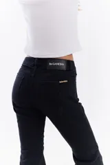 Jean de denim negro estilo oxford con recortes frontales y botamanga con terminación deshilachada.
