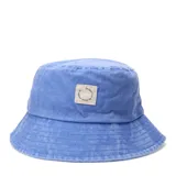 Gorro tipo bucket color celeste con efecto lavado, presenta un parche cuadrado de tela en el frente con diseño circular y texto impreso.