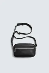 Bandolera negra con textura grabada, compartimento principal con cierre de cremallera, bolsillo interior con cremallera, bolsillo frontal con cremallera y asa de hombro ajustable.