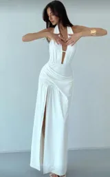 Vestido largo blanco de tela tricotada, con escote halter y abertura en la pierna.