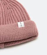 Gorro tipo fisherman de tejido acrílico con textura acanalada, diseño corto y etiqueta pequeña con logo en el frente.