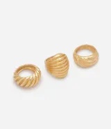Kit de tres anillos femeninos de metal en color dorado, con diseño bold, formatos ondulados, textura estriada y acabado pulido.