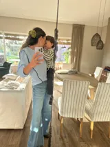 Camisa celeste a rayas verticales blancas, con cuello en V y mangas 3/4 abullonadas.