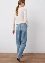 Jeans de tiro medio en denim azul con lavado medio, corte recto y amplio, diseño clásico de cinco bolsillos y cierre frontal con botón y cremallera.