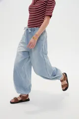 Pantalón jean de corte globo con cintura elástica y cordón ajustable, tiro medio y botamangas fruncidas con elástico.