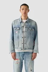 Campera de jean azul claro con efecto desgastado, cuello clásico, cierre frontal de botones, dos bolsillos en el pecho con solapa y botón, y dos bolsillos laterales. Presenta parches decorativos en el pecho y la manga, y un forro rojo con estampado de puntos blancos en el interior de la manga.