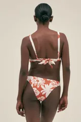 Bombacha de bikini color blanco con estampado de flores color ladrillo y aro metálico en el lateral.