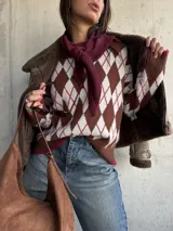 Sweater de tejido de punto con diseño de rombos en tonos chocolate, blanco y detalles en bordó. Presenta cuello redondo, mangas largas y terminaciones acanaladas en puños y ruedo.