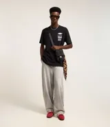 Pantalón de jean corte baggy, de tiro alto y pierna ancha, con diseño de cinco bolsillos, trabillas para cinturón y cierre frontal con botón y cremallera.