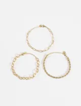 Set de tres pulseras de acero quirúrgico hipoalergénico color dorado. Incluye una pulsera de eslabones ovalados, una de eslabones texturizados y una de cadena trenzada.
