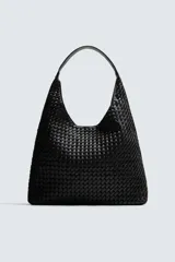 Bolso de hombro tipo hobo o shopper, color negro, con cuerpo de material trenzado. Posee un asa de hombro y un bolsillo interior con cierre de cremallera.