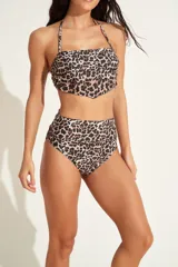 Conjunto de bikini de dos piezas con estampado animal print tipo leopardo. El corpiño es tipo bandeau con tirantes finos para anudar al cuello, y la bombacha es de tiro alto con corte clásico.