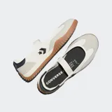 Zapatillas tipo ballerina Converse, confeccionadas en lona con revestimientos de gamuza. Presentan una banda elástica en el empeine, detalle de logo de estrella y galón en el lateral, y una suela de goma dentada con tracción.