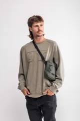 Buzo color verde oliva con cuello redondo y mangas largas, corte oversize y logo 'UY' en relieve en el frente.