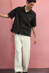 Camisa de denim negro, corte regular fit, con cuello resort, manga corta, tapeta lisa y bajo recto.