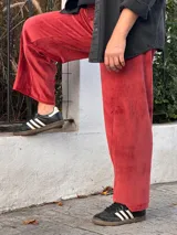 Pantalon de corte barrel en plush de algodon color bordó, con tiro medio, bolsillos frontales y traseros, y faja ancha en la cintura.