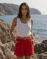 Short de lino color azul marino, de tiro alto, con bolsillos laterales y e incluye un cinto de rafia con hebilla redonda.