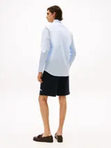 Camisa celeste de manga larga con logo de Tommy Hilfiger bordado en el pecho.