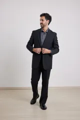 Traje de corte clásico compuesto por saco de dos botones y pantalón de vestir a juego. Saco con solapas tradicionales y bolsillos con solapa, pantalón de corte recto.