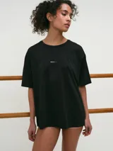 Remera deportiva blanca de manga corta, cuello redondo y corte oversized con tecnología dry fit.