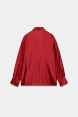 Camisa de ZARA Woman Collection confeccionada en hilatura con mezcla de lyocell, de color blanco marfil. Presenta cuello redondo, escote en V con lazadas en el mismo tejido, manga larga con puño y bajo recto.