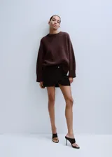 Sweater de punto marrón, de corte oversize, con mangas largas amplias, hombros caídos y cuello redondo acabado en rib acanalado.
