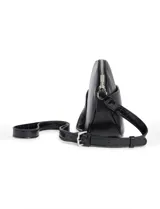 Cartera tipo bandolera de silueta redondeada, confeccionada en cuero sintético negro. Presenta un bolsillo frontal con textura efecto cocodrilo, detalle de cadena metálica plateada decorativa y correa ajustable con la misma textura. Incluye logo de la marca en la parte frontal.