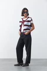 Jean de corte barrel con silueta curva y volumen controlado, de tiro medio y color negro. Presenta un diseño que se ensancha en la pierna y se ajusta levemente en el bajo, con cierre frontal y bolsillos laterales.