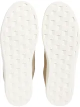 Zapatillas bajas de cuero color beige con logo CK bordado en el lateral y suela blanca con el nombre de la marca.