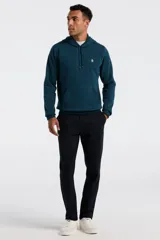 Hoodie de color azul petróleo con capucha, cordones ajustables y bolsillo tipo canguro frontal. Presenta el logo de la marca bordado en el pecho.