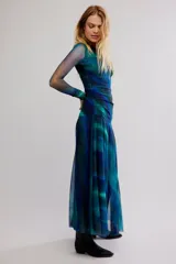 Vestido largo de tul con estampado degradado en tonos azules y verdes, manga larga, escote bote y diseño drapeado en el torso.