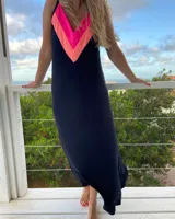 Vestido largo negro de tirantes finos, con escote en V y detalle de bloques de color fucsia y coral en la parte superior.