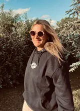 Hoodie negro con cordones ajustables y estampado de una hoja blanca en el frente.