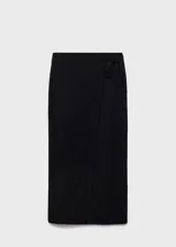 Falda midi tiro medio de color negro, con diseño cruzado y tajo delantero.