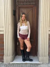 Body de encaje blanco con mangas largas y cuello redondo.