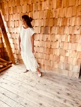 Vestido tejido color blanco con hilo metalizado, corte oversized, mangas cortas y flecos en el ruedo.