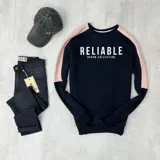 Buzo negro con mangas color rosa pálido y texto estampado en blanco que dice 'Reliable Duxon Collection'.