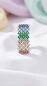 Anillo de plata 925 con diseño de banda ancha compuesto por múltiples circonias de colores engastadas en forma de rombos.