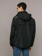 Campera ligera Calvin Klein de corte regular, confeccionada en tejido técnico resistente al viento y la llovizna. Presenta cierre frontal con cremallera, capucha ajustable con cordones, bolsillos laterales con cierre y puños elásticos.