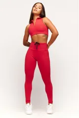 Top deportivo negro, estilo crop top, con cuello polo y escote en V. Presenta tirantes anchos y corte ajustado al cuerpo.