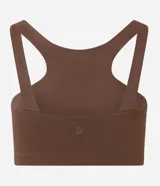 Top deportivo de mujer con diseño halter, confeccionado en microfibra de poliamida y elastano. Cuenta con copas integradas y breteles anchos en la espalda para mayor soporte.