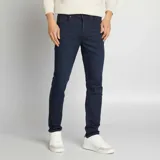 Pantalón de jean de corte slim, color azul oscuro, con bolsillos delanteros y traseros.