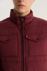 Chaleco puffer Levi's color borgoña con cierre frontal, cuello alto y dos bolsillos con solapa en el pecho.